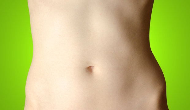 Stomach. Beautiful female body isolated on green background.