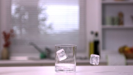 Two ice cubes falling in an empty glass - Powered by Adobe