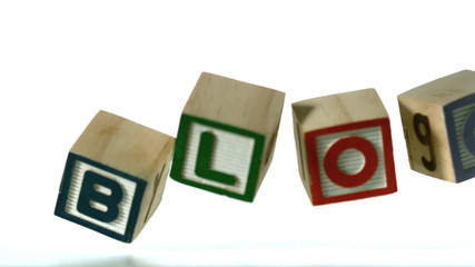 Row of blocks spelling Blog falling over - Powered by Adobe