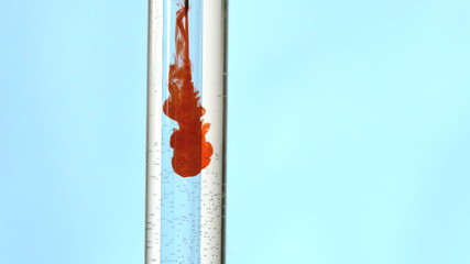 Syringe injecting blood in test tube of water - Powered by Adobe