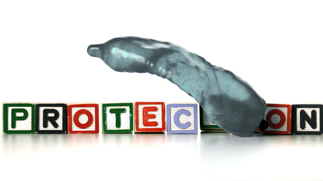 Condom with water bouncing front of blocks spelling protection