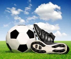 Foto op Plexiglas voetbal en schoenen in gras © vencav