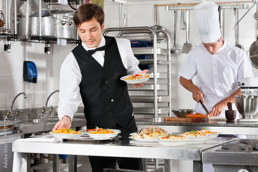 Wall mural waiter and chef working in commercial kitchen