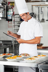 Young Chef With Clipboard At Kitchen