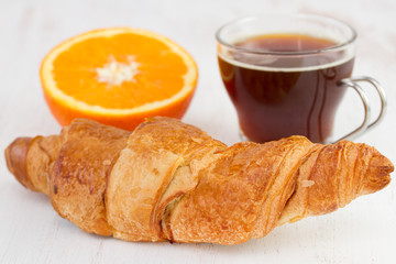 croissant with cup of coffee and orange