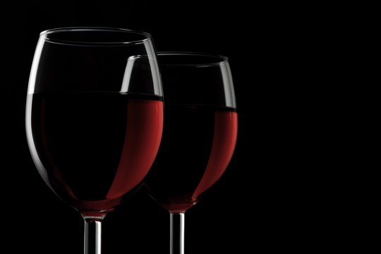 Two glassed of red wine isolated on black background