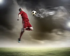 Fotobehang voetballer die de bal slaat © Sergey Nivens