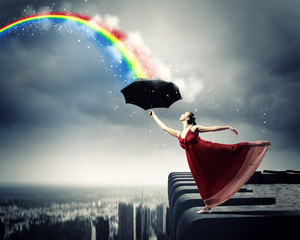 Ballet dancer in flying satin dress with umbrella