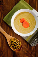 Bowl with green bean soup, on a wooden background