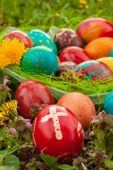 Colorful easter eggs with flowers, outside. Red egg with a cross