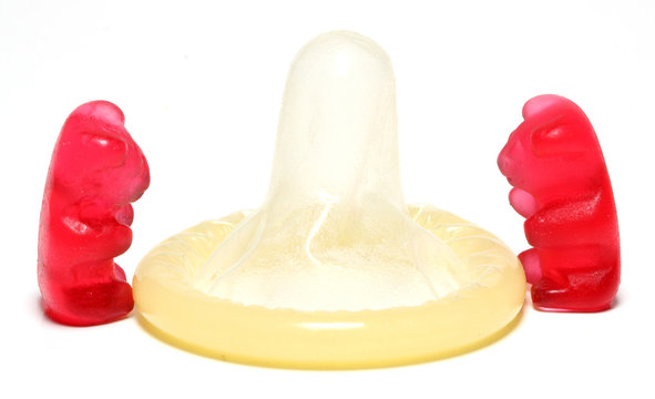 Red jelly figurine and a condom - birth control concept.