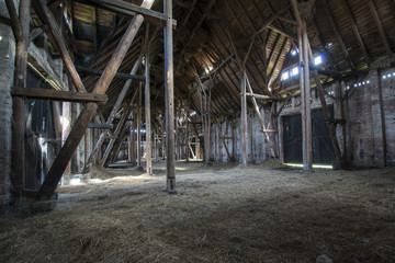 Fototapeta na wymiar Stare drewniane stodoły z światło świeci przez desek