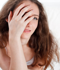 Fototapeta premium Portrait of a young girl closing her eye with a hand