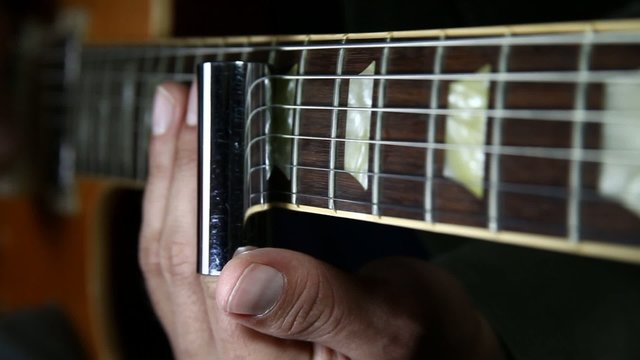 Electric Guitar player playing with a a slide