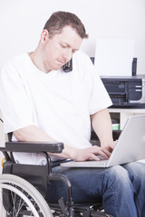 young man in wheelchair using a laptop