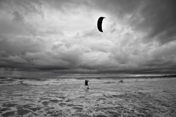 Kitesurfer gets in the water during a storm.