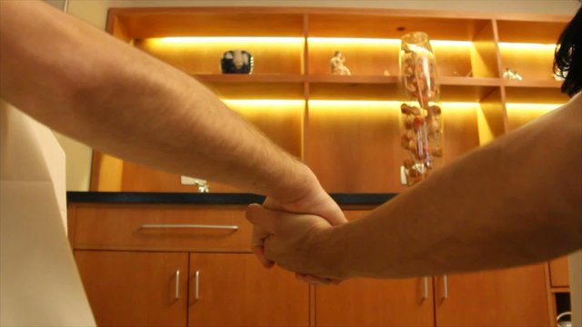 Two men hold their hands