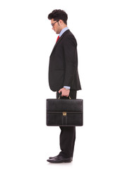 man with suitcase looks down