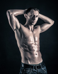 Fototapeta na wymiar Confident young man shirtless portrait against black background.