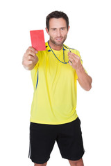 Soccer judge whistling and showing yellow card