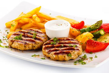 Grilled steaks, French fries and vegetables