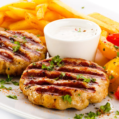 Grilled steaks, French fries and vegetables