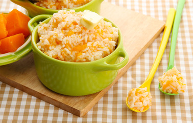 Taste rice porridge with pumpkin in saucepans