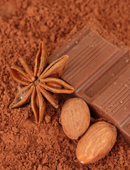 Chopped chocolate with cocoa, on brown background