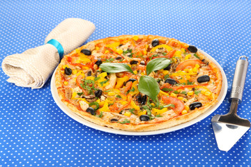 Tasty pizza on blue tablecloth close-up