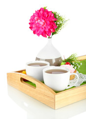 Cups of tea with flower and cake