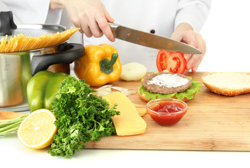Female hands preparing cheeseburger, isolated on white
