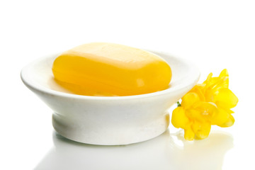 Soap-dish with soap and flower isolated on white