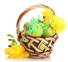 Bright easter eggs with bows in basket, isolated on white