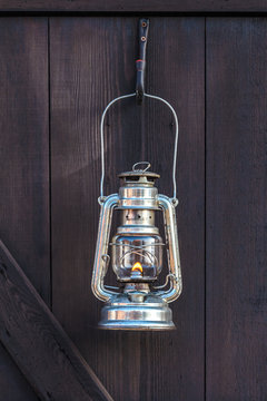 Old fashioned lantern on a brown wooden wall
