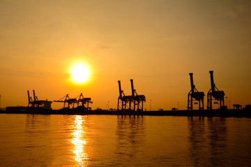 Obraz premium Container cargo freight ship silhouette in the morning