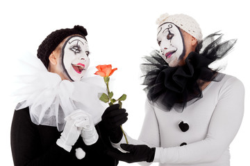 Zwei Clowns mit Blume zeigen sich verliebt