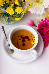 Cup of tea with flower on table