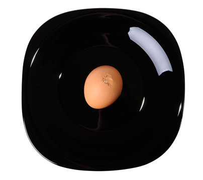 Cracked egg on a black plate