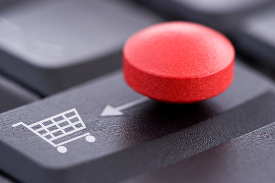 Red Pill and Shopping Cart on Computer Keyboard