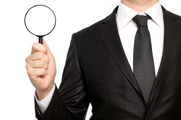 Isolated businessman in a suit holding a magnifying glass