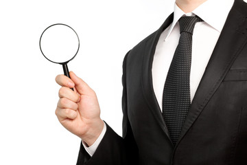 Isolated businessman in a suit holding a magnifying glass