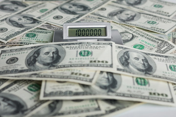 Background of $ 100 bills and a calculator