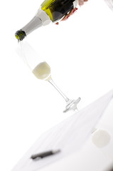 Woman pouring champagne into a glass over a contract