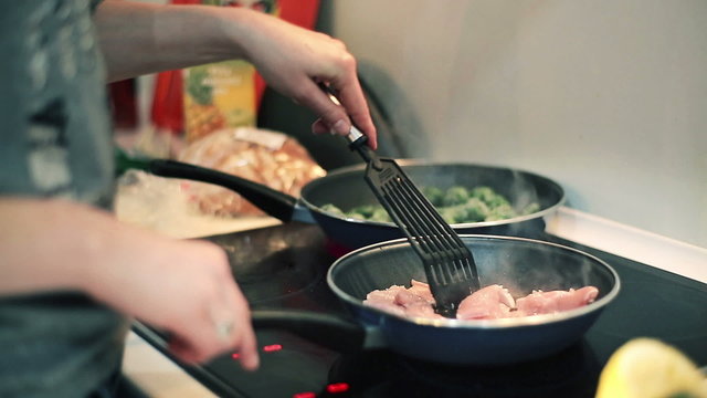 Woman hands frying chicken meat on pan