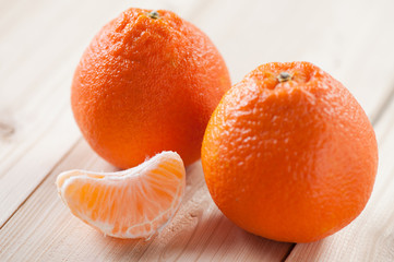 Two ripe tangerines and their segment, close-up, studio shot