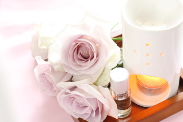 Fototapeta na wymiar purple roses and aroma oil for home spa image