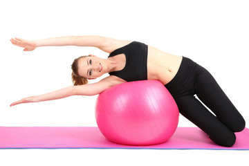 Fototapeta premium Young woman doing fitness exercises with gym ball isolated