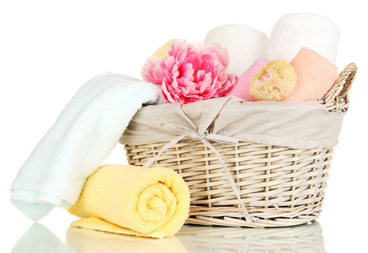 Bathroom towels folded in wicker basket isolated on white