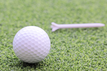 Golf ball with tee. Green grass