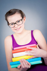 Teenager Mädchen mit großer Brille und vielen Büchern